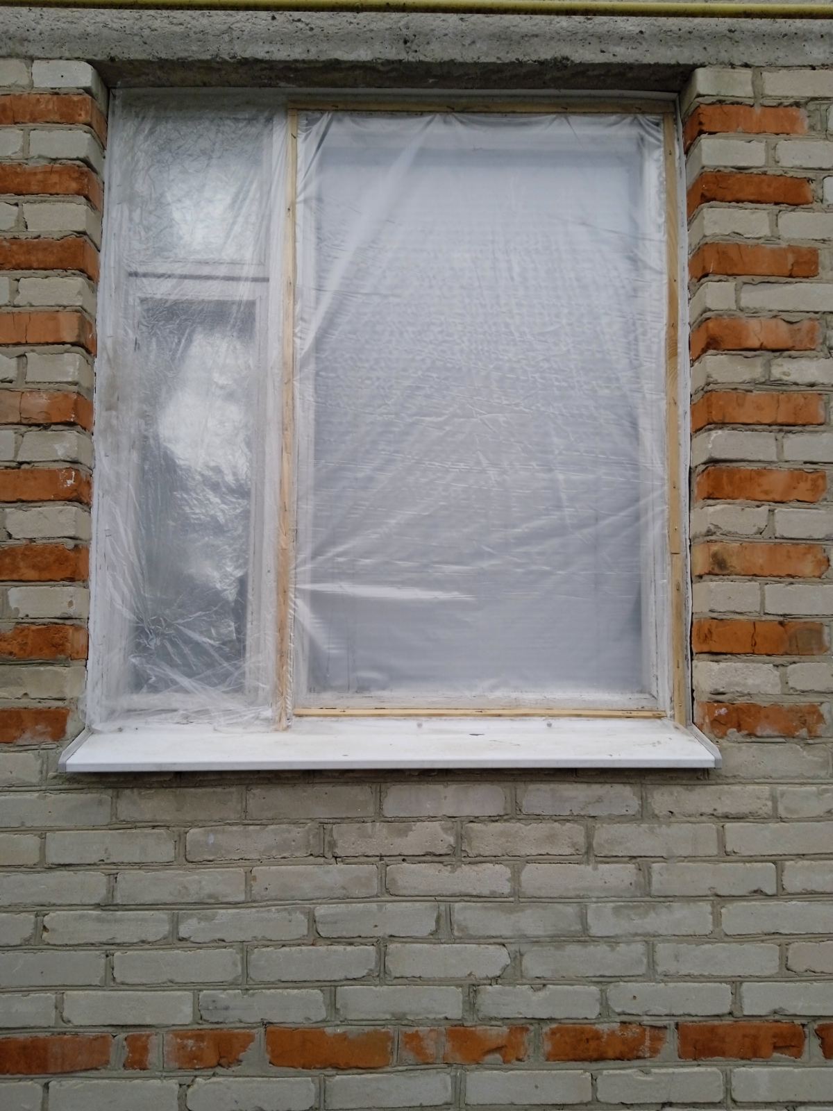 Родина з маленькою дитиною мешкає в будинку з розбитими вікнами