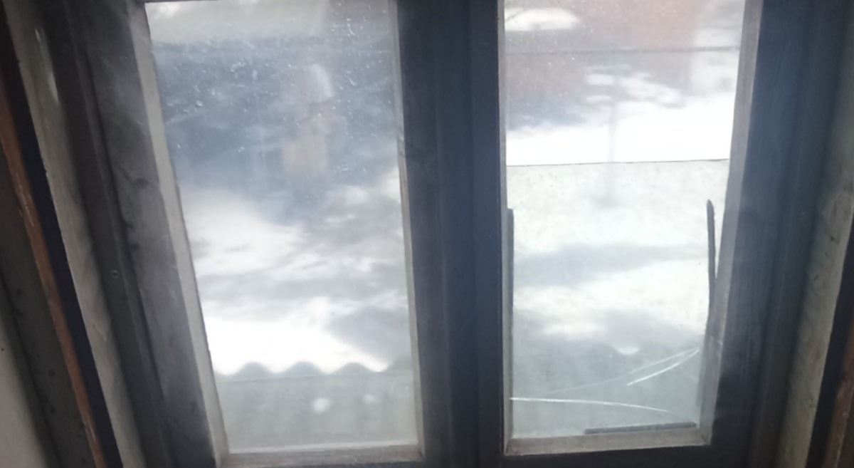 Чоловік доглядає за старенькою тещою в пошкодженому обстрілами будинку